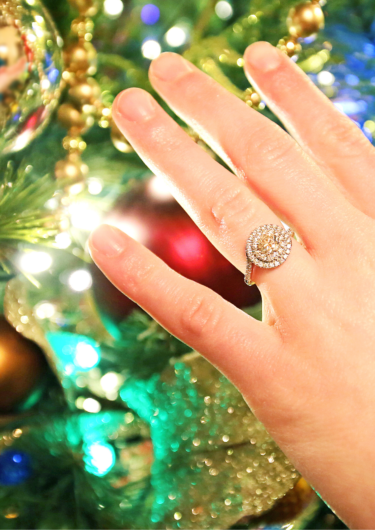 クリスマスツリーと指輪をしている手の画像